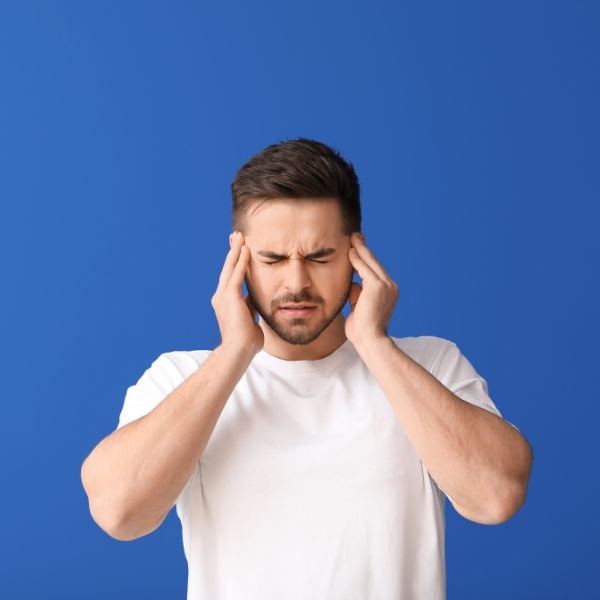 man holding his ears in pain