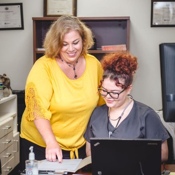 two staff members stand together and discuss results