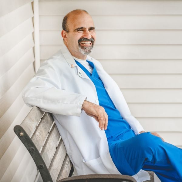 hearing specialist on a bench smiling